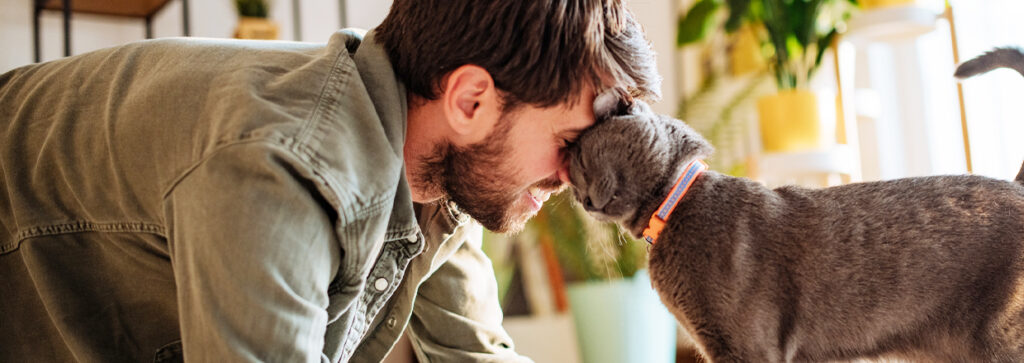 Smiling cat parent nuzzling his happy cat
